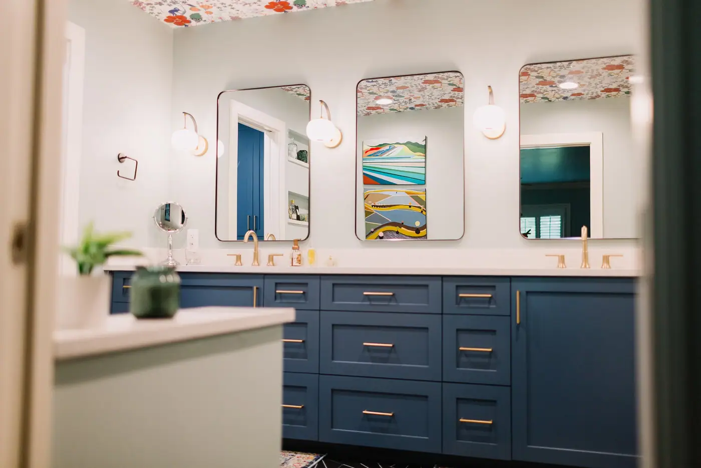 A navy double vanity with brass pulls and three black-framed mirrors in an Overton Park primary bath