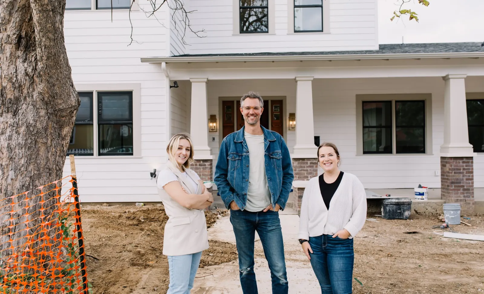 Three members of the 6th Avenue Homes team standing on the front walk of a newly built house