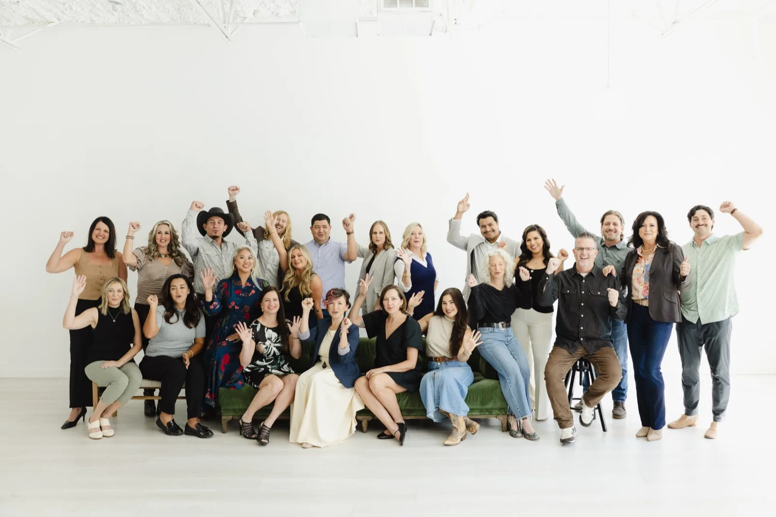 The whole 6th Avenue Homes team, design, construction, and real estate, cheering together in a white studio